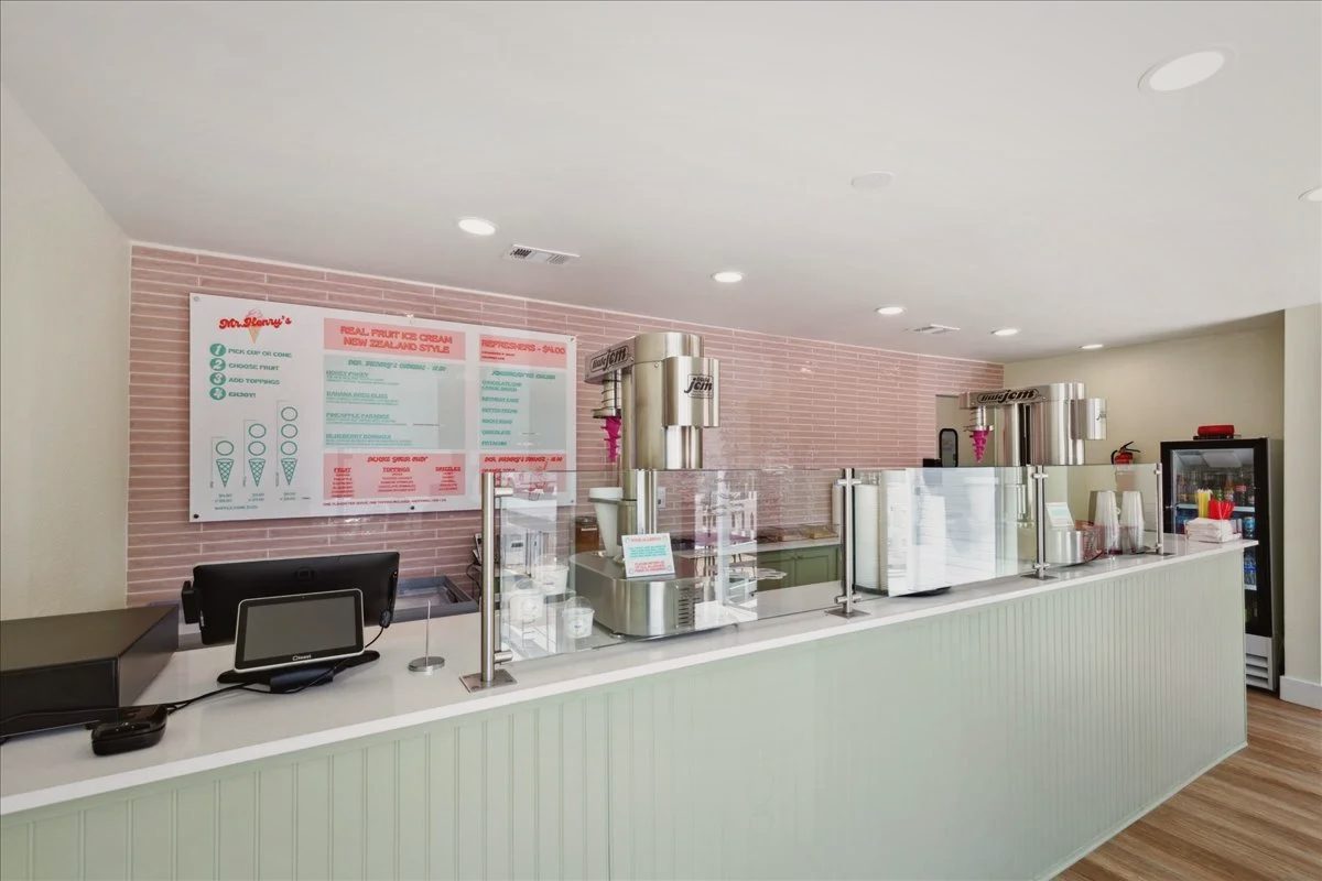 Ordering counter with sage green beadboard, a pink tile wall and the menu board