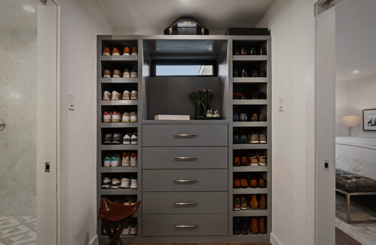 Closet with gray built-in drawers and open shoe shelves